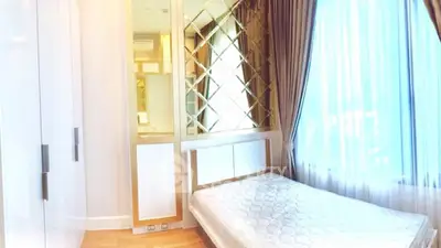Luxurious bedroom with elegant mirrored wall and large window for natural light.