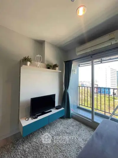 Modern living room with balcony view, featuring sleek TV setup and air conditioning.