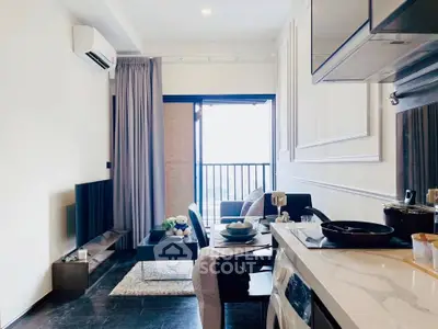 Modern living room with balcony, stylish decor, and open kitchen layout.