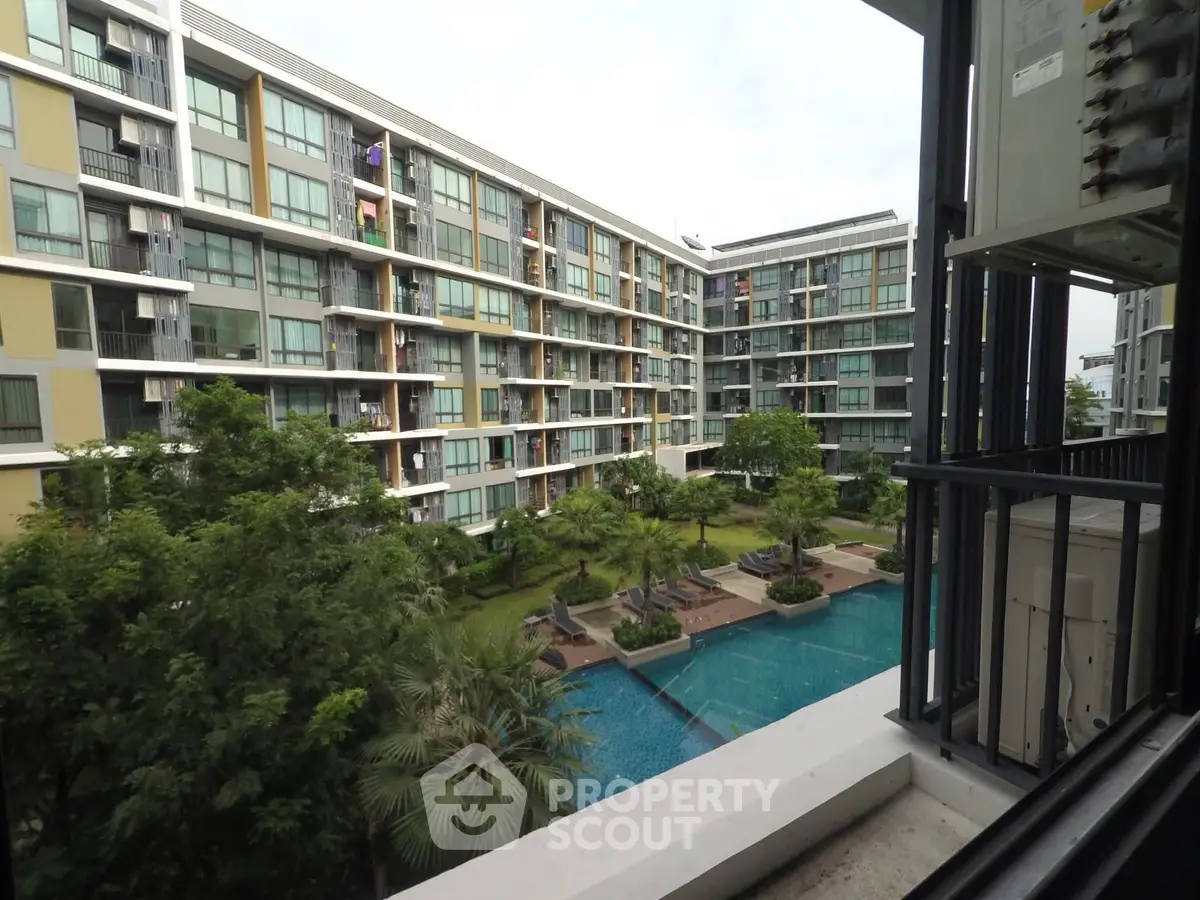 Modern apartment complex with pool view and lush greenery