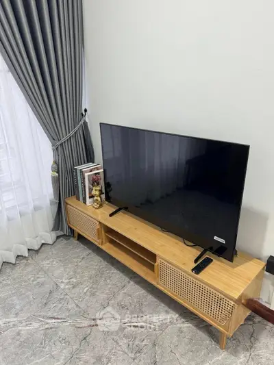 Modern living room with sleek TV stand and elegant curtains, perfect for stylish home entertainment setup.
