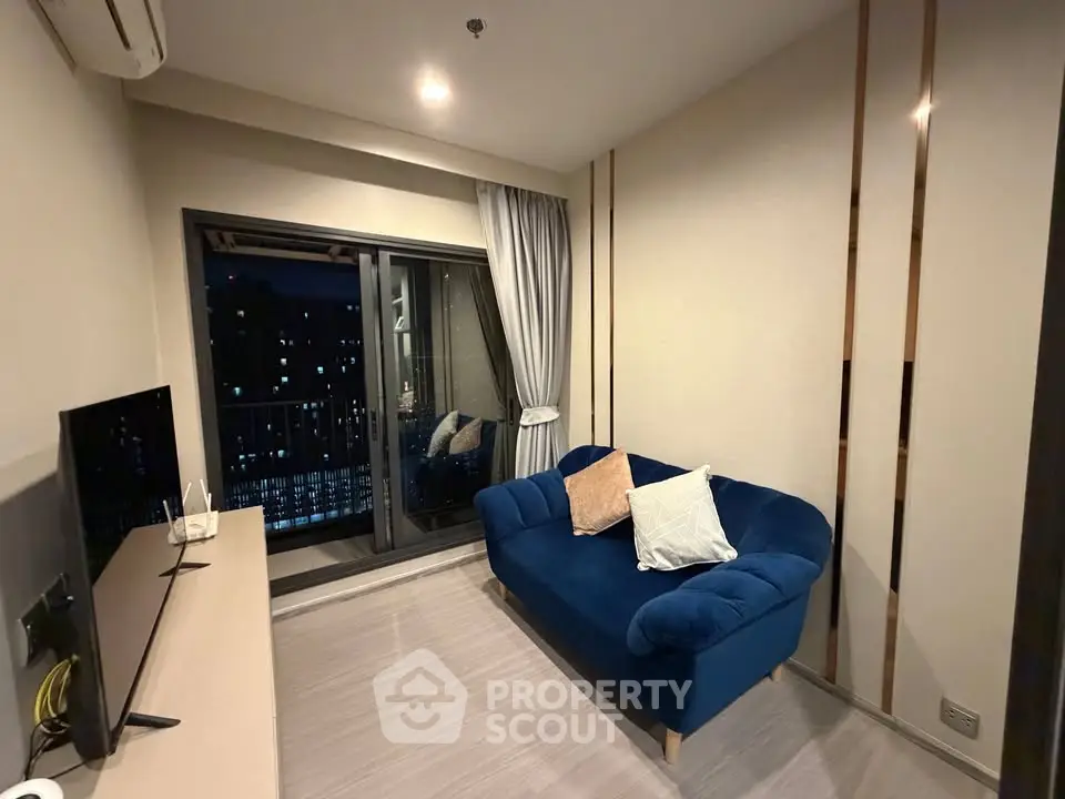 Modern living room with blue sofa and balcony view in a stylish apartment.