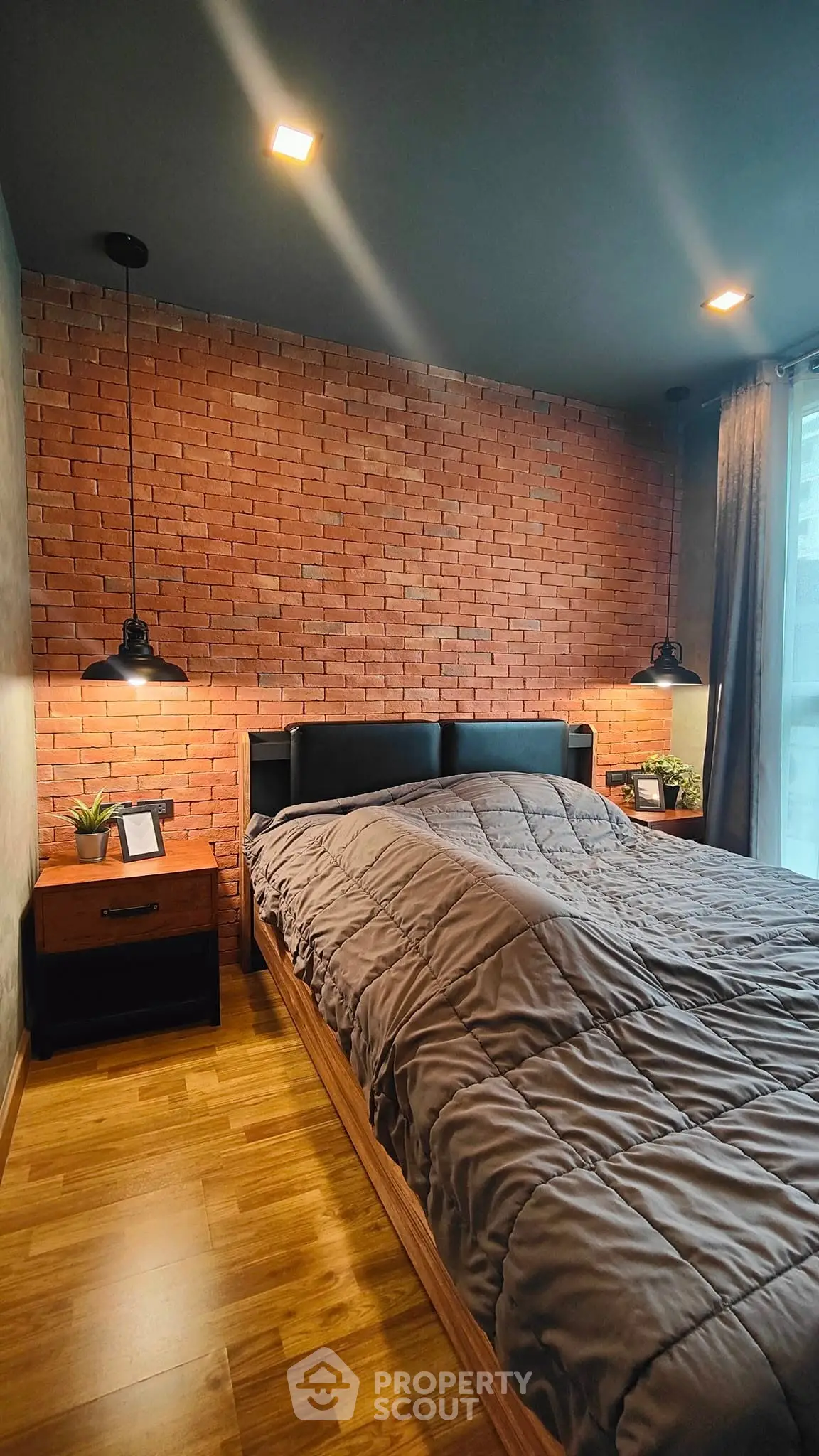 Cozy bedroom with brick accent wall and modern lighting