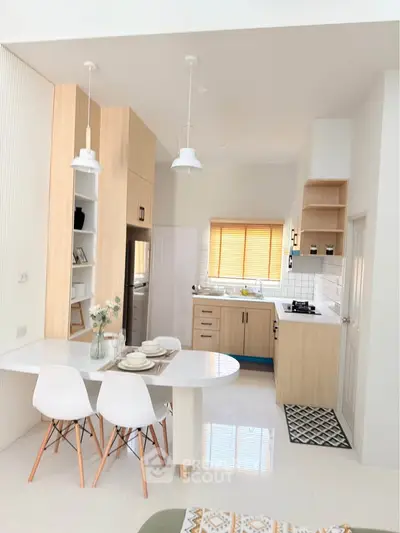 Modern kitchen with open layout, sleek cabinetry, and dining area in stylish apartment.