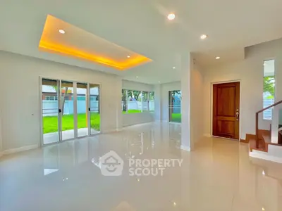 Spacious modern living room with large windows and elegant lighting