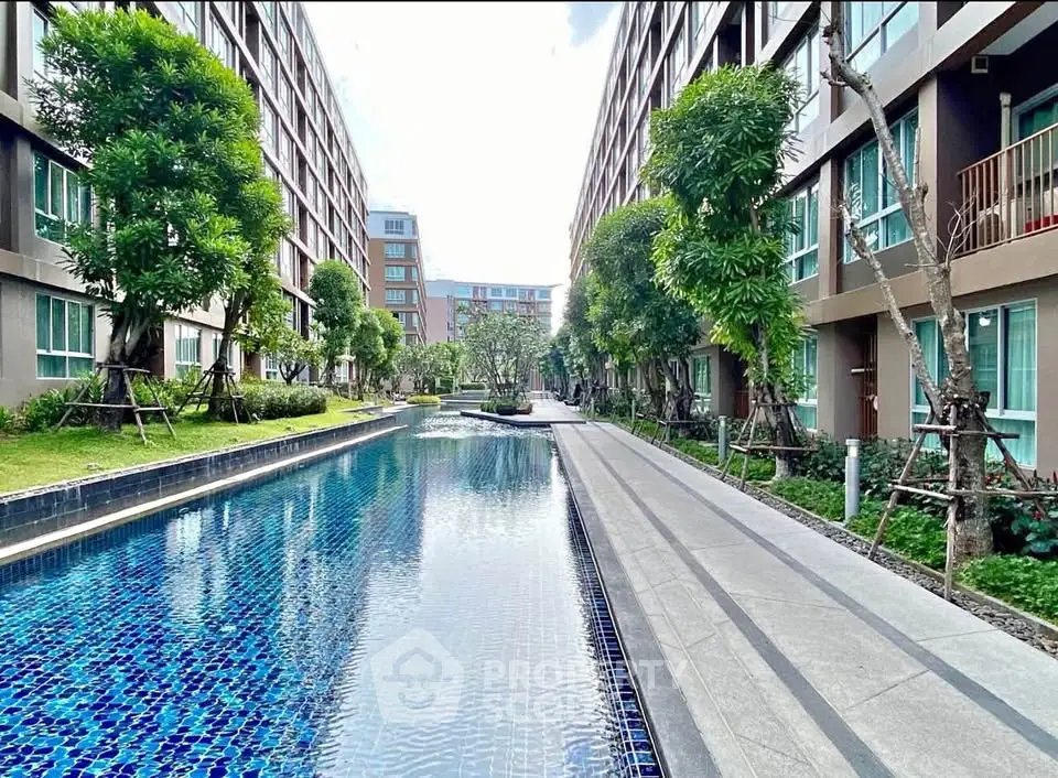 Luxurious apartment complex with stunning pool and lush greenery