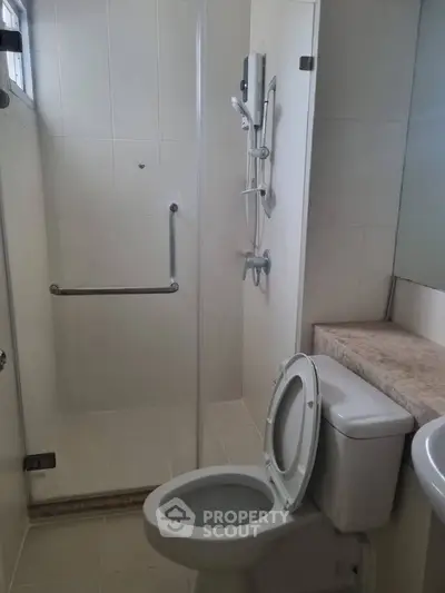 Modern bathroom with glass shower and sleek fixtures in a contemporary home.
