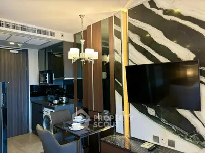 Modern apartment interior with stylish decor, featuring a wall-mounted TV and compact dining area.