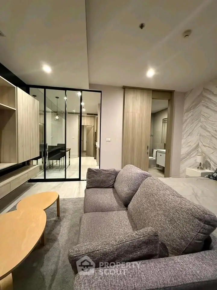 Modern living room with stylish furniture and open layout, featuring a cozy sofa and elegant decor.