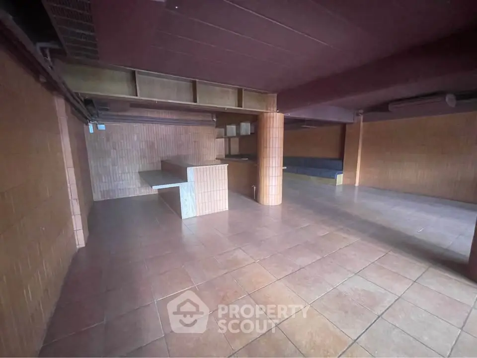 Spacious basement with tiled flooring and wooden accents, ideal for storage or renovation.