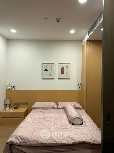 Cozy bedroom with modern decor and soft lighting, featuring a comfortable bed and stylish artwork.