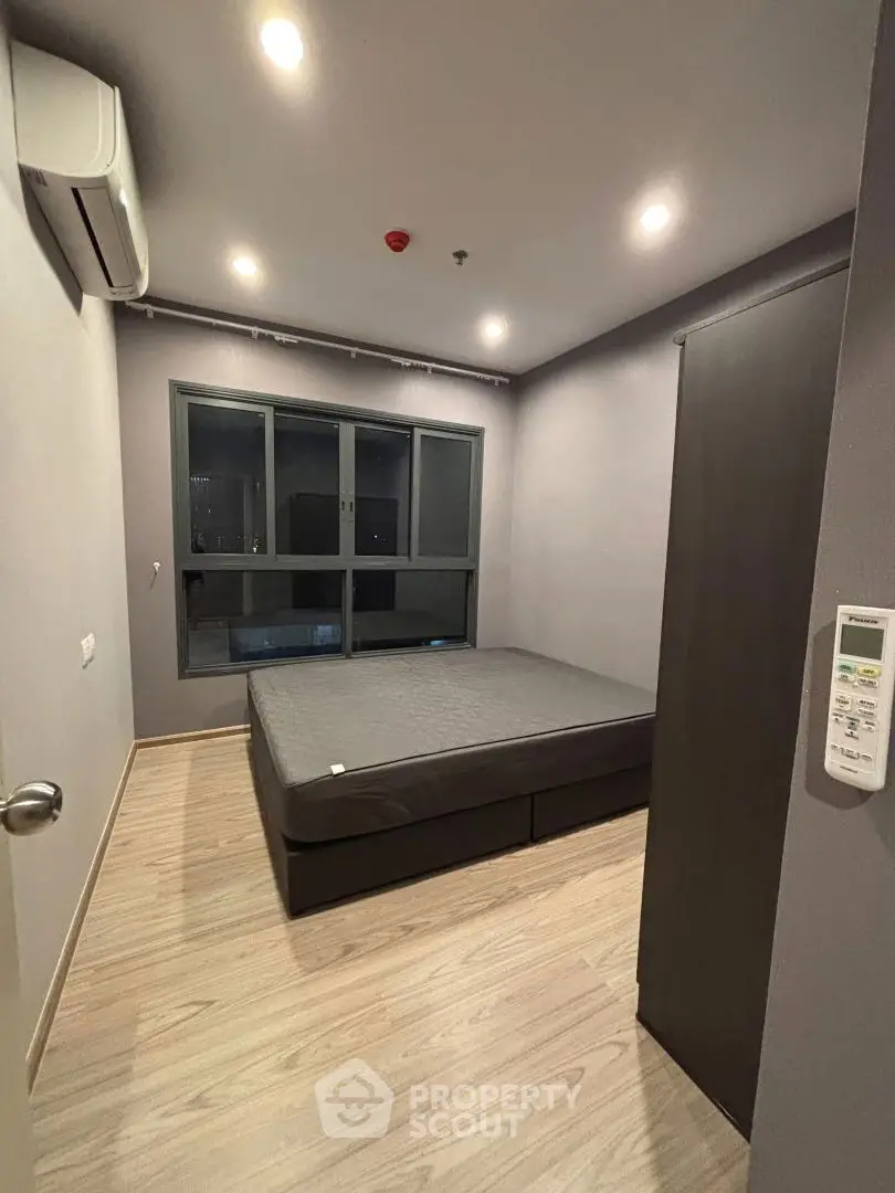 Modern bedroom with large window and sleek design in urban apartment