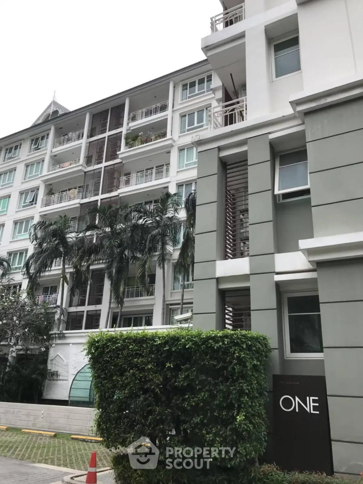 Modern condominium building with lush greenery and contemporary design