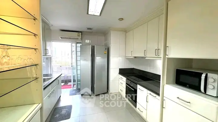Spacious modern kitchen with sleek appliances and ample storage in a bright, airy setting.