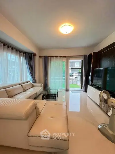 Spacious living room with modern decor and large windows offering natural light.