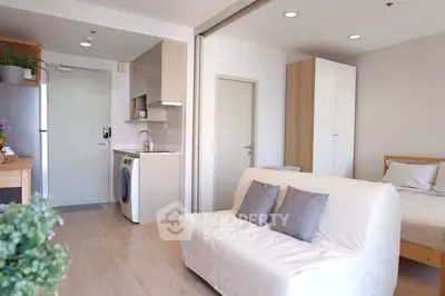 Modern studio apartment with open layout, featuring a cozy living area, compact kitchen, and stylish decor.
