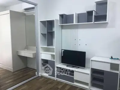 Modern living room with sleek shelving and mounted TV in a stylish apartment.
