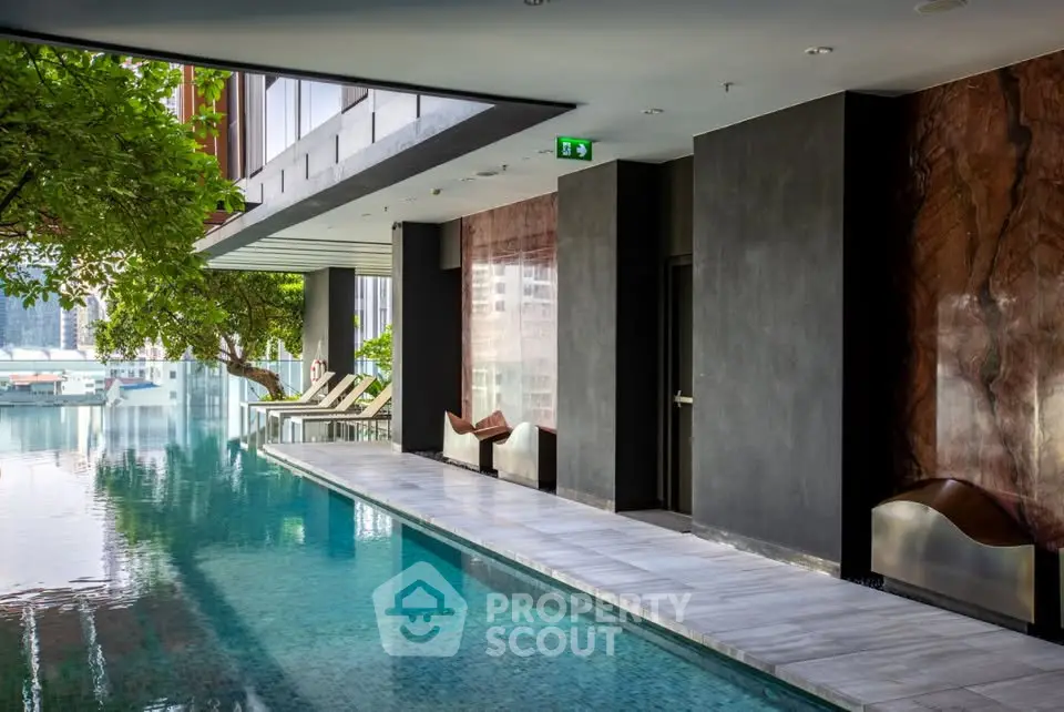 Luxurious modern indoor pool area with sleek design and city views, perfect for relaxation and leisure.