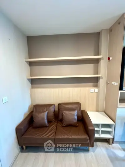 Modern living room with stylish brown leather sofa and wooden shelves, perfect for cozy relaxation.