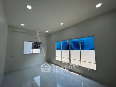 Spacious and bright room with large windows and modern lighting