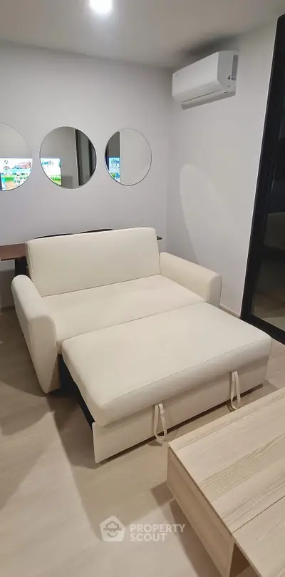 Modern living room with a stylish sofa bed and minimalist decor, perfect for urban living.