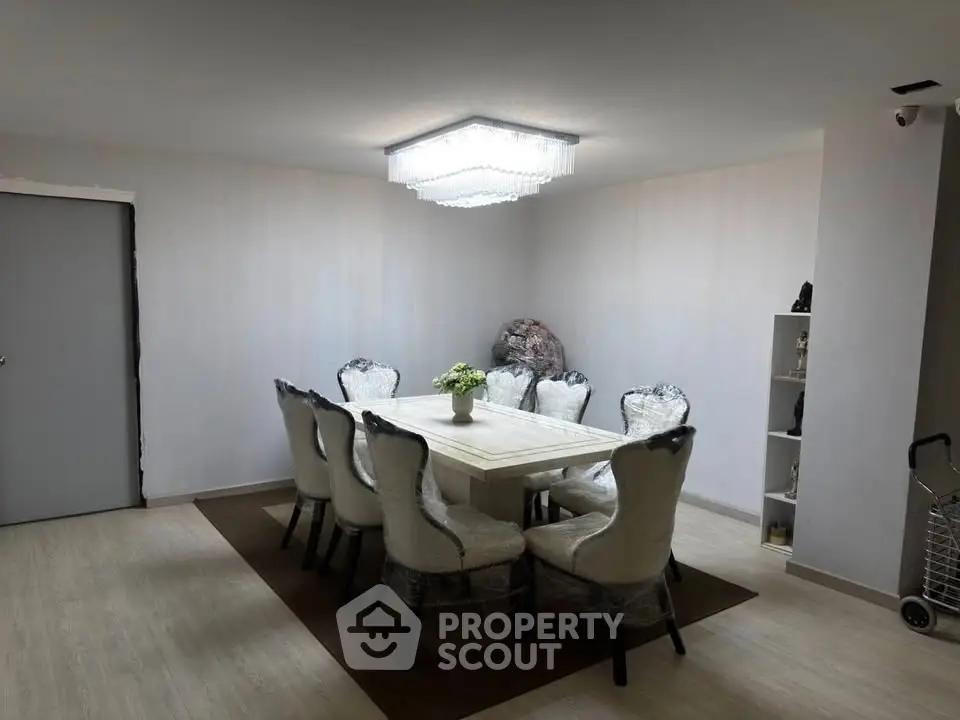 Elegant dining room with modern chandelier and stylish chairs around a sleek table, perfect for hosting gatherings.