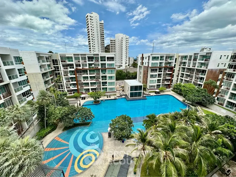 Luxurious condominium complex with stunning pool and lush greenery, offering modern urban living in a vibrant community.