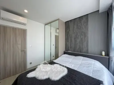 Modern bedroom with sleek design, mirrored wardrobe, and cozy bedding in a stylish apartment.