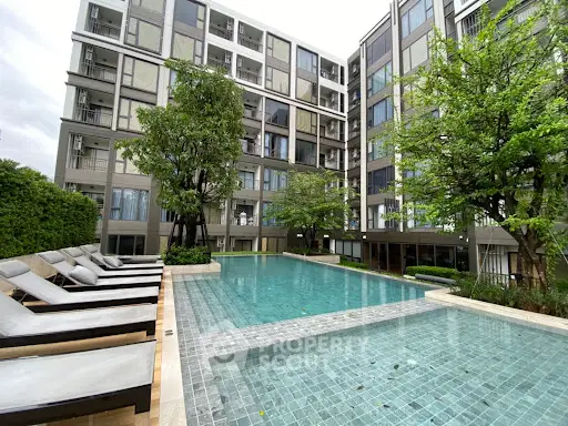 Luxurious apartment complex with modern pool and lush greenery