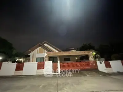 Charming suburban home with red fence and driveway, perfect for family living.