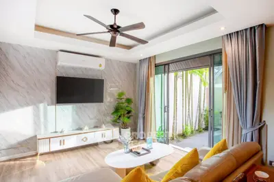 Modern living room with ceiling fan and sliding glass doors to garden