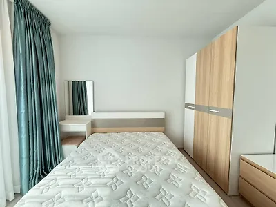 Modern bedroom with stylish wardrobe and elegant curtains in a bright apartment.