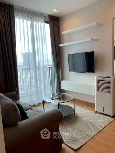 Cozy living room with modern decor and city view, featuring a sleek TV setup and comfortable seating.