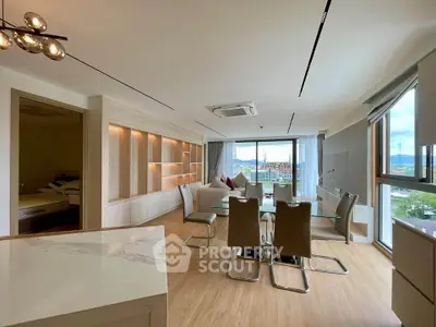Spacious modern living room with dining area and large windows offering scenic views.