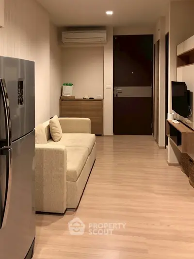 Modern apartment interior with cozy living room and sleek kitchen appliances.