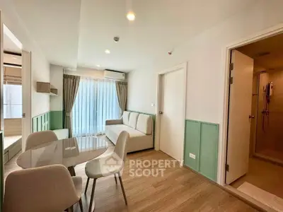 Modern living room with dining area and view into bathroom, featuring stylish decor and natural light.
