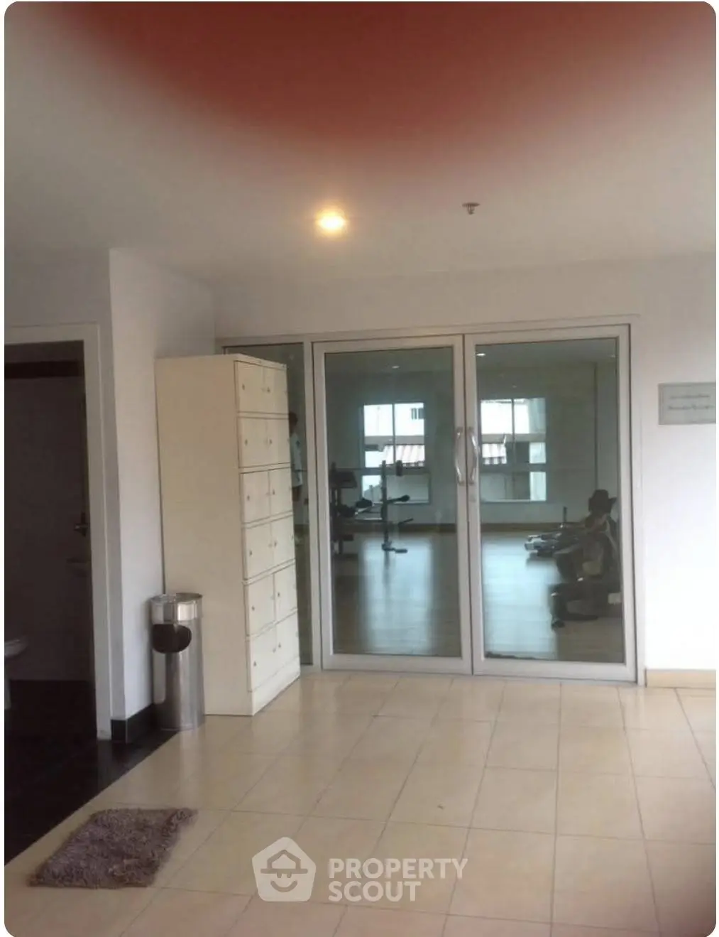 Modern gym entrance with glass doors and sleek interior design.