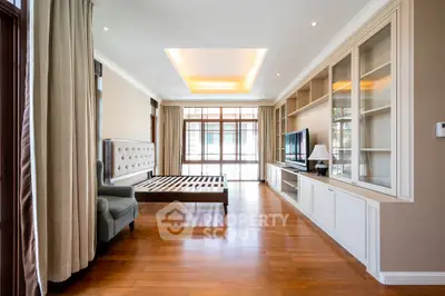 Spacious bedroom with elegant wooden flooring and built-in storage