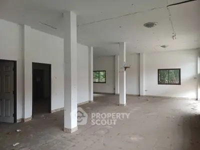 Spacious open-plan interior with large windows and tiled flooring, ideal for customization.