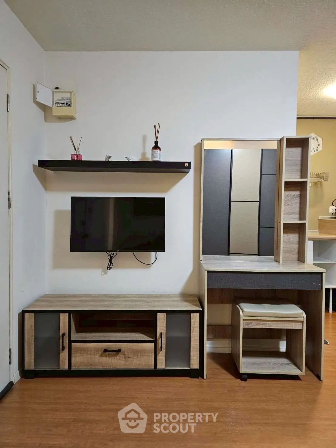 Modern living room with stylish TV unit and wooden flooring, perfect for cozy home entertainment setup.