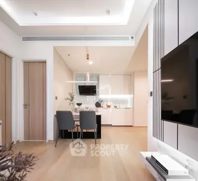 Modern open-plan living room with sleek kitchen and dining area, featuring minimalist design and elegant decor.