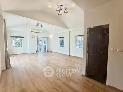 Spacious and bright living room with wooden flooring and large windows