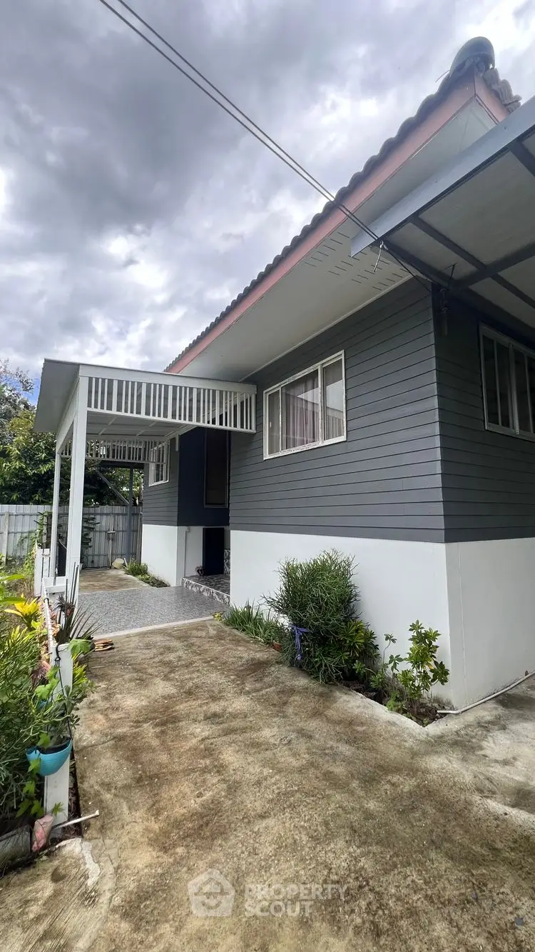 Charming single-story home with covered porch and lush garden, perfect for serene living.