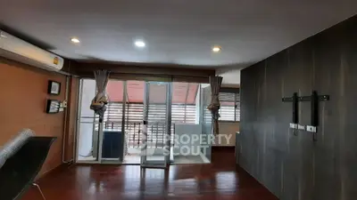 Spacious living room with balcony access and modern lighting