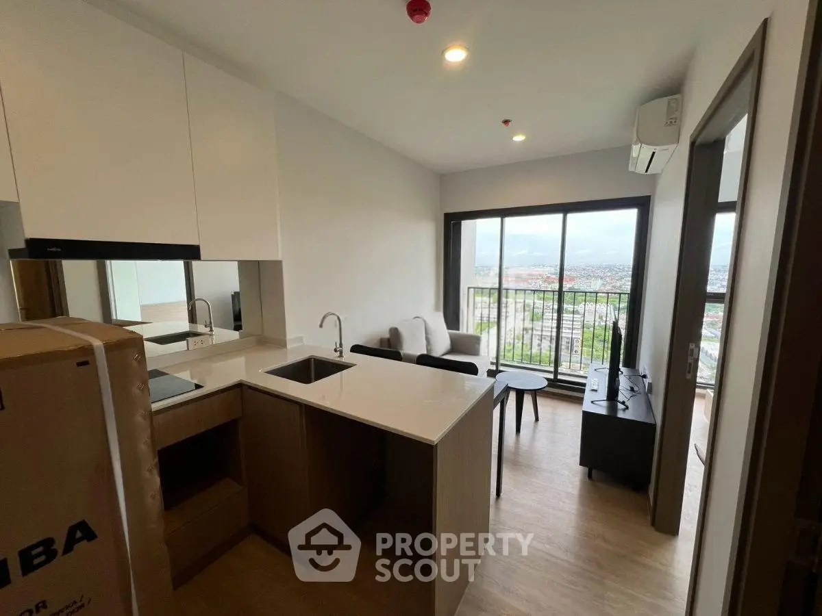 Modern open-layout kitchen and living room with balcony and city view