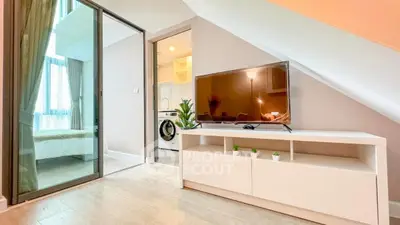 Modern living room with TV, washing machine, and bedroom view in stylish apartment.