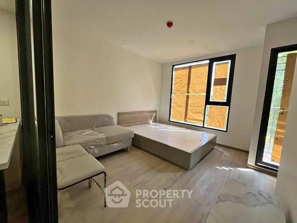 Modern unfurnished bedroom with large windows and wooden flooring