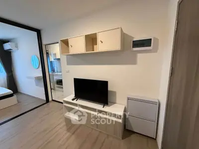 Modern living room with sleek TV stand and wall-mounted storage in a stylish apartment.