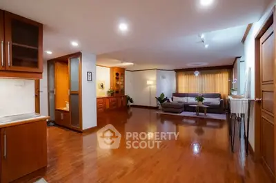 Spacious living room with wooden flooring and modern decor in a cozy apartment.
