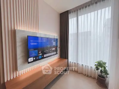 Modern living room with sleek TV setup and large window view.